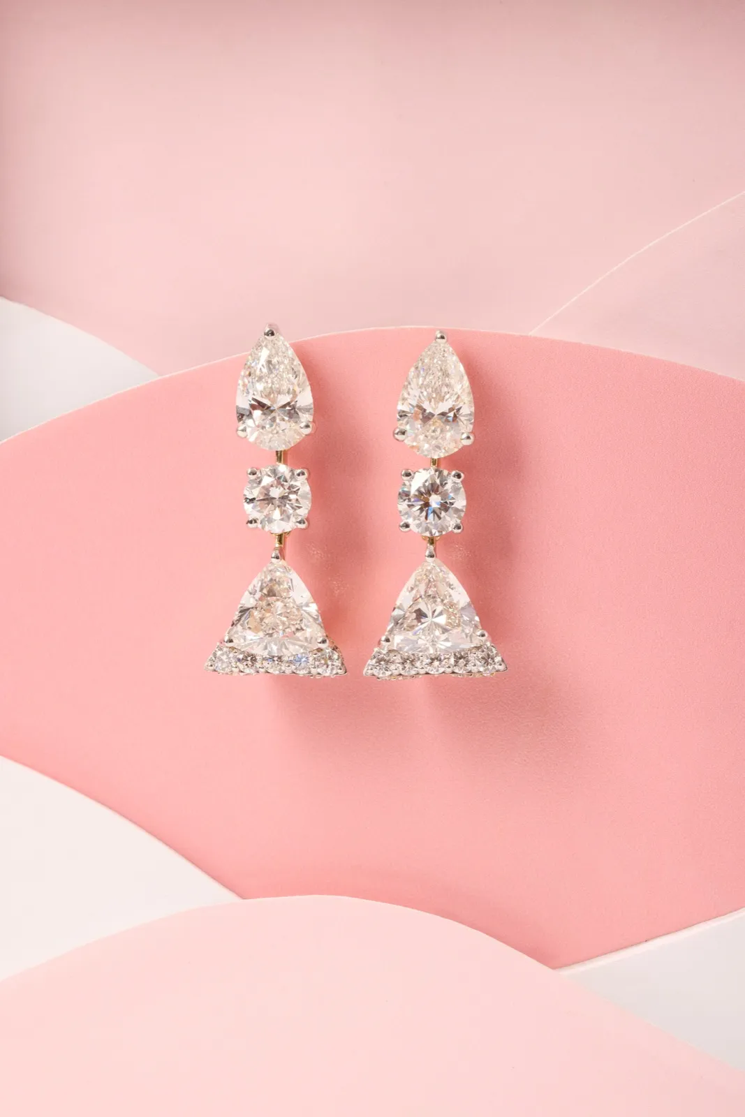 Diamond dangler earrings resting on a pink envelope